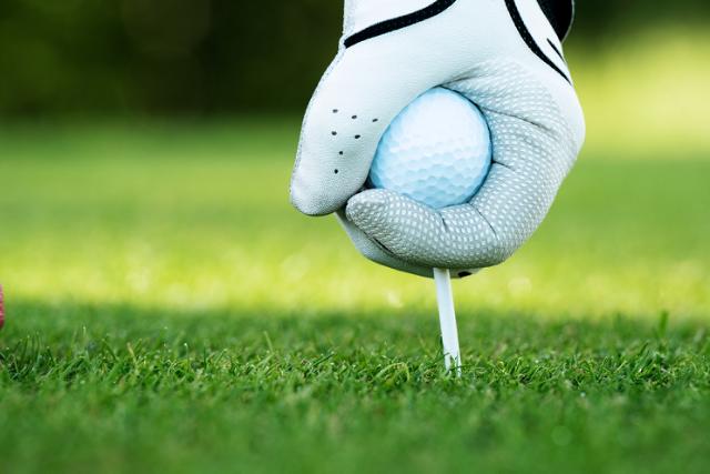 main tenant un tee de golf